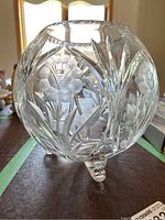 Side view of the footed crystal bowl showing etched rose and floral patterns with three small feet.