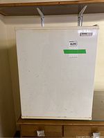 Closed front view of white Danby mini fridge with visible manufacturer logo and stickers on door.