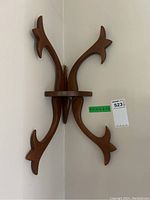 Full view of the decorative wooden corner shelf mounted on a wall corner showing the overall design and finish.