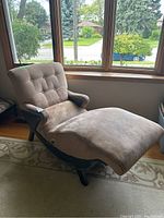 Electric lounger chair positioned next to window, showing full profile with fabric and bonded leather accents.