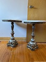 Side-by-side view of both matching marble tables showing full height and base design