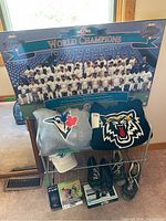Front view of complete lot showing 1992 Toronto Blue Jays World Champions poster, two sweatshirts, cap, shoes, shoe rack, and accessories