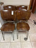 Set of four vintage dining chairs with chrome frames and brown vinyl upholstery, showing front and side views