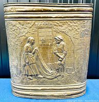 Front side showing embossed pub or tavern scene of a man and woman outside a brick building with trees.