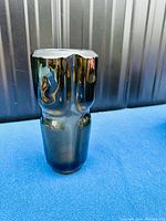 Side view of the smoked glass vase showing its reflective, faceted geometric form with a smoky grey tint.