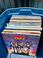 Full view of blue plastic bin filled with assorted LP record sleeves, front cover showing Kiss “Destroyer”