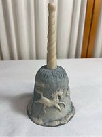 Overall view of the incolay stone unicorn bell showing handle and bell shape.