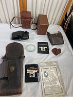 Full view of all cameras, cases, and accessories on white surface