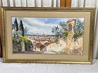 Full view of the watercolor print framed, showing the artwork and part of the frame in beige with gold accents.