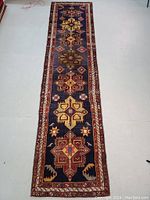 Full length view showing geometric multicolored medallion pattern on navy blue field