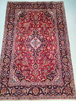 Full view of rug laid flat showing central medallion and border pattern