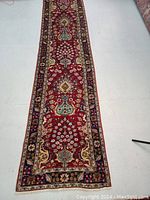 Full-length view of red floral runner laid out on white floor