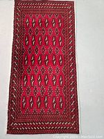 Top view of the Persian Turkman rug displaying the red field with repeating geometric motifs and multiple border bands.