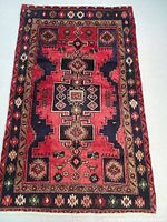 Full front view of rug showing overall geometric design with navy blue and red background and border patterns