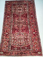Full view of rectangular Persian rug showing triple medallion design with cobalt blue and red background and patterned borders.
