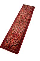 Oblique angled view showing the full length of the Baluch runner rug with geometric patterns in red, black, yellow and white.