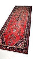 Full view of the Persian Hamadan rug laying flat showing overall geometric floral patterned design in red with dark borders.