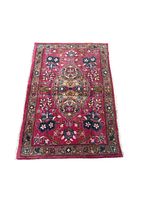 Full view of small handmade Persian Mashhad rug in pink floral pattern laid flat on white background, showing overall design and colors.