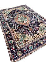 Angled view of entire rug on white background showing full medallion and border pattern