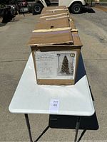 Photo of the cardboard box placed on white folding table outdoors, showing the overall packaging condition.