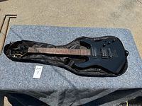 Full view of the Mitchell electric guitar in its black soft case showing the guitar body, neck, and headstock.