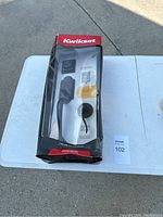 Boxed Kwikset SmartKey front entry door lock set on white table showing entire packaging with box wear.