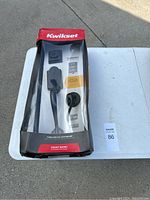 Boxed Kwikset front door handle set with packaging visibly damaged on corners and edges but contents appear new.