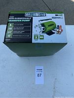 Closed original box of Drummond 12V non-submersible transfer pump showing pump specifications and branding.