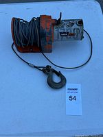 Full view of Warn V100 electric winch mounted with cable wound around the spool and a metal hook attached to cable end.