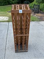 Front view of wooden wine rack showing vertical slatted design and multiple wine slots.