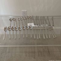 Full set of Dansk Danish stainless steel cutlery arranged showing all pieces: large forks, knives, large spoons, small spoons, soup spoon, and small forks.
