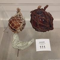 Photo showing both glass fishing float buoys and the concrete dove figurine.