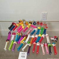 Photo shows the entire lot arranged on the floor including 36 colorful Pez dispensers with various character heads, 7 rubber ducks with different designs and colors, and a small Super Mario Nintendo cart toy.