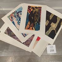 Group of art prints fanned on metal surface