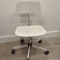 Front view of the white vintage Danish office chair with caster wheels, showing the five-point metal base and seat.