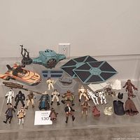 Photo showing Land Speeder, TIE Fighter wings, numerous Star Wars figures laid out on table