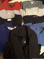 Nine wool tops in various colors and brands arranged to show variety in color and style.