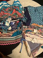 Photo showing folded assorted swimwear pieces including bikini tops and bottoms in various colors and patterns.
