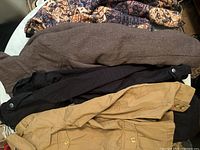 Four women's light jackets in assorted colors and styles folded together showing variety in design and color.