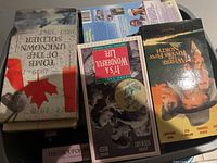 Top view of assorted VHS tapes showing titles including 'The Group of Seven', 'It's A Wonderful Life', 'Where The Rivers Flow North', and a historical or biographical movie titled 'Unmarked Soldier 1939-1991'