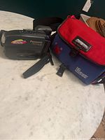 Panasonic PV-L550 video camera and accompanying Panasonic branded carrying bag on marble surface.