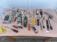 View of the full assortment of tools spread on a table showing various hand tools including planes, wrenches, screwdrivers, socket sets.