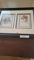 Front view of the framed Indigenous art with two prints, Raven on left and Salmon on right.