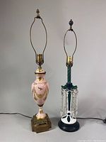 Two vintage table lamps together; the pink Italian urn style lamp is on the left with brass base, and the green to white Czech Bohemian glass lamp with hanging crystals is on the right.