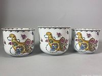 Front view of three signed Hutschenreuther porcelain planter bowls with Ole Winther floral and bird designs