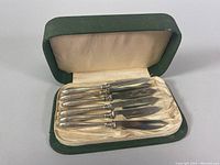 Photo of the set of six vintage fruit knives displayed inside the original green lined case showing the overall set condition and case details.