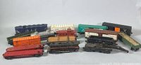 Photo of multiple vintage Lionel train cars including flatbed, boxcars, tankers, and others in various colors and logos.