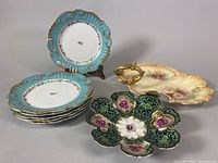 Photo showing six 8-inch luncheon plates stacked, the 8-inch floral lotus dish, and the 11-inch Royal Devon serving plate with chips.