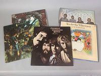 Five classic rock vinyl albums including Janis Joplin, Cat Stevens, The Doors, and Creedence Clearwater Revival with visible album artwork.