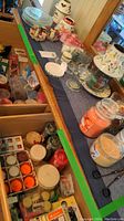 Wide view showing various candle types, candle holders, and incense holders on a flat surface and drawer.